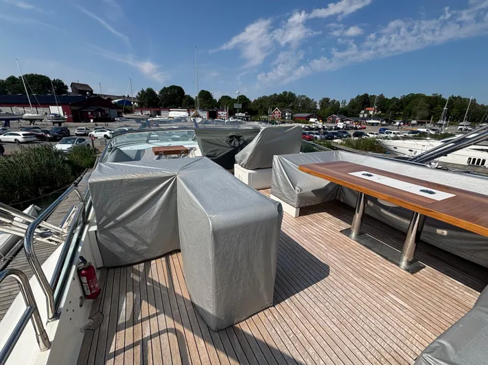 Schatzi Yacht Photos Pics 2013 Fairline Squadron 78 Custom yacht deck with covered seating and table, docked at marina.