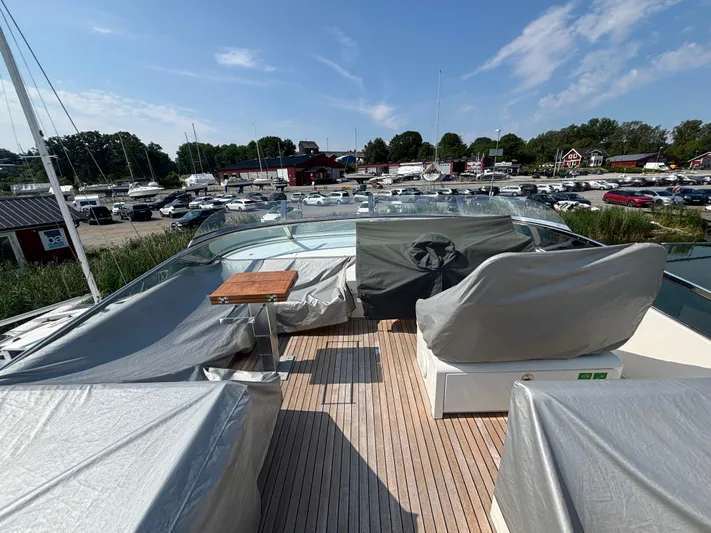 Schatzi Yacht Photos Pics 2013 Fairline Squadron 78 Custom yacht deck with covered seating and table, docked at marina.