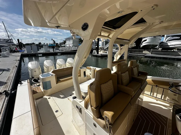  Yacht Photos Pics 2025 Scout 400 LXF luxury boat interior with seating and multiple outboard engines at a marina.