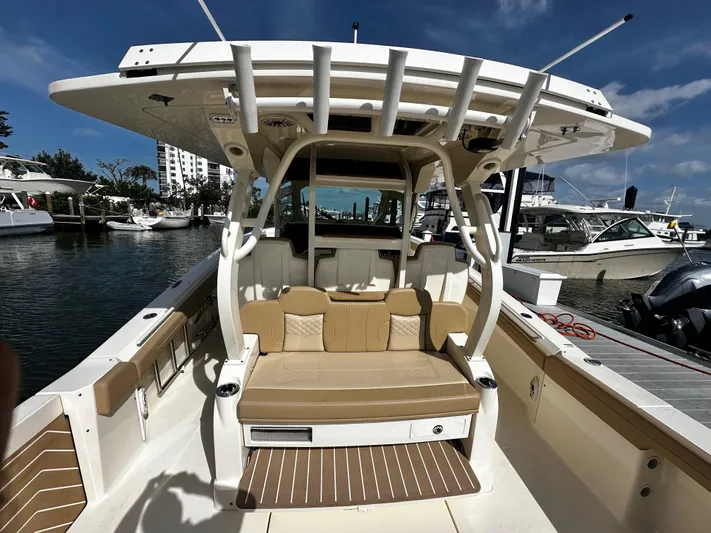  Yacht Photos Pics 2025 Scout 400 LXF boat interior with seating, docked at marina under clear sky.