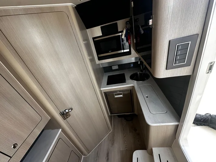  Yacht Photos Pics 2025 Scout 400 LXF interior kitchen with modern cabinetry and compact design.