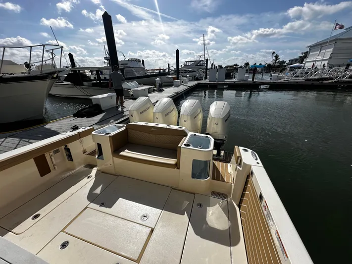  Yacht Photos Pics 2025 Scout 400 LXF boat docked at marina, featuring four powerful outboard engines.