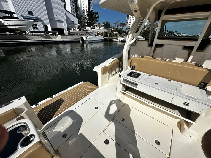  Yacht Photos Pics 2025 Scout 400 LXF boat interior at marina, featuring seating and storage.