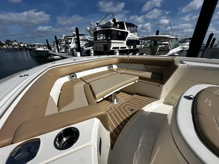  Yacht Photos Pics 2025 Scout 400 LXF boat interior with tan seating, docked at marina under blue sky.