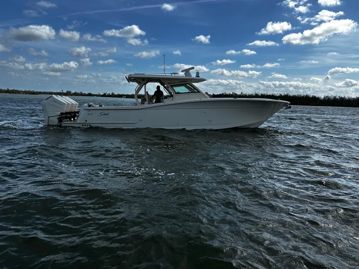  Yacht Photos Pics 2025 Scout 400 LXF boat cruising on a sunny day with blue skies.