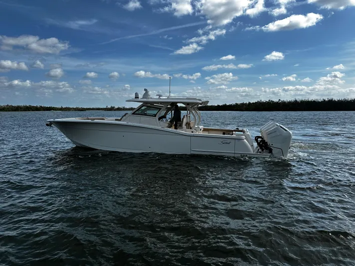  Yacht Photos Pics 2025 Scout 400 LXF boat on water under blue sky with clouds.