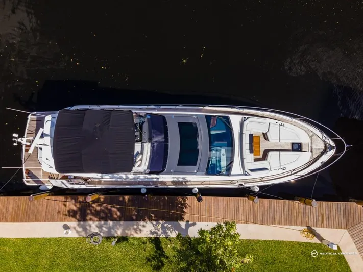  Yacht Photos Pics Aerial view of 2023 Fairline Phantom 65 yacht docked by a wooden pier.