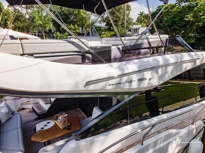  Yacht Photos Pics 2023 Fairline Phantom 65 luxury yacht with outdoor seating and dining area.