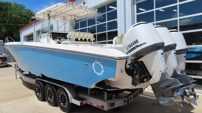  Yacht Photos Pics 2002 Fountain 38 TE boat with Yamaha engines on a trailer, parked outside a building.