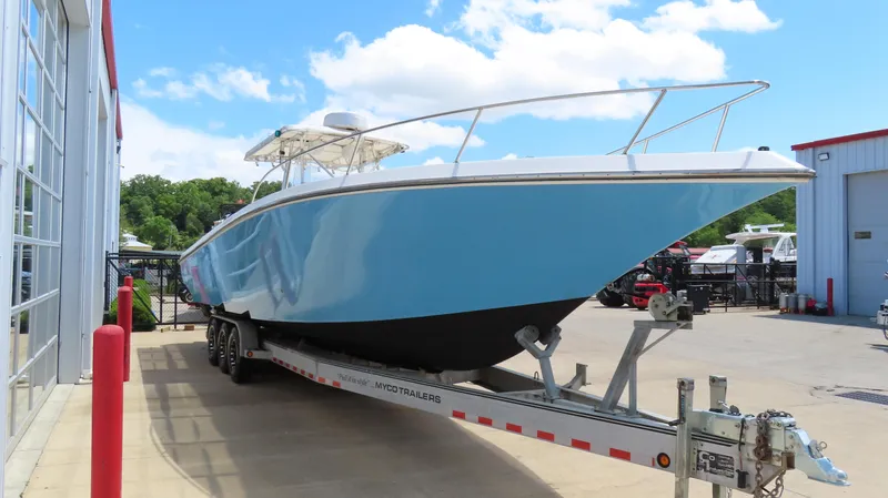 Yacht Photos Pics 2002 Fountain 38 TE boat on trailer, blue hull, parked outdoors near buildings.