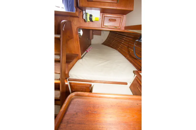 Equanimity Yacht Photos Pics Cozy cabin interior of 1992 Pacific Seacraft Cutter with wooden finish and comfortable bedding.
