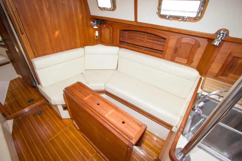 Equanimity Yacht Photos Pics Interior of 1992 Pacific Seacraft Cutter with wooden finish and cream seating.