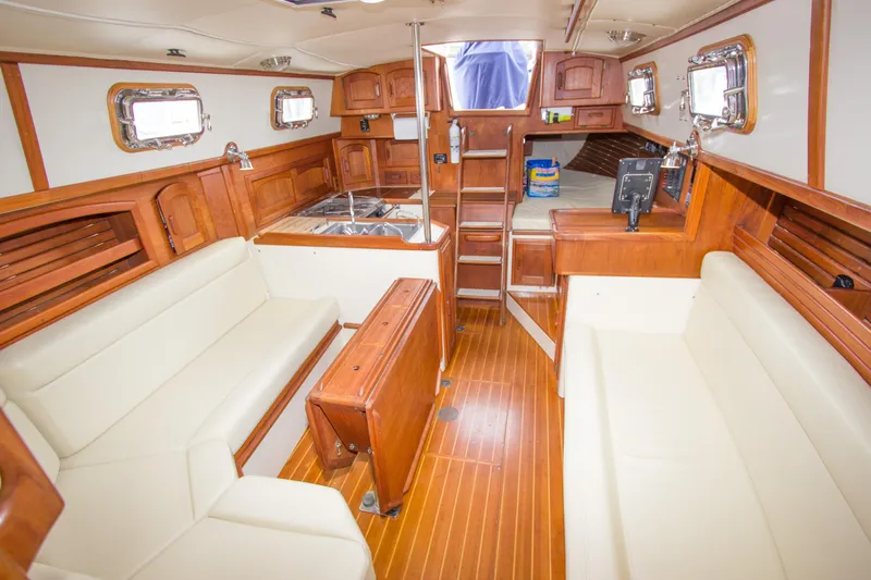 Equanimity Yacht Photos Pics Interior of 1992 Pacific Seacraft Cutter sailboat with wooden finishes and white seating.