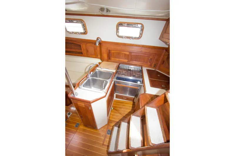 Equanimity Yacht Photos Pics Interior of 1992 Pacific Seacraft Cutter, featuring wooden cabinetry and compact kitchen area.