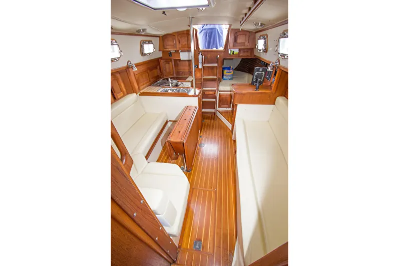 Equanimity Yacht Photos Pics Interior of 1992 Pacific Seacraft Cutter sailboat with wooden finish and seating area.