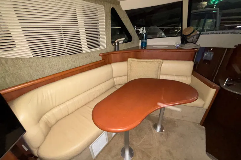  Yacht Photos Pics Interior of 2005 Silverton 34 Convertible yacht with beige seating and wooden table.