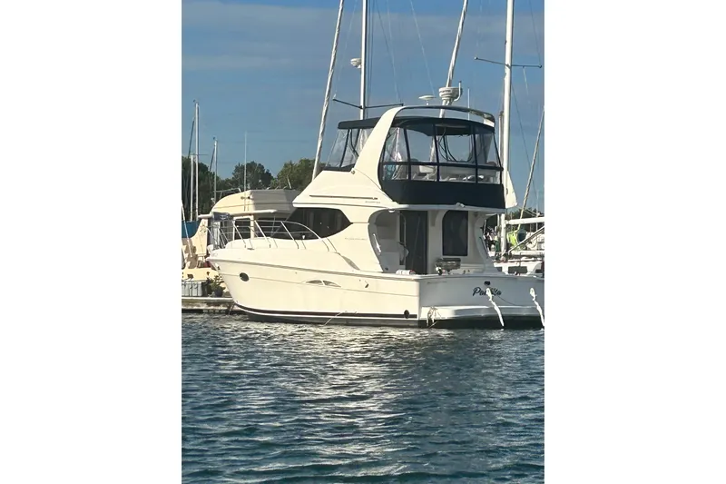  Yacht Photos Pics 2005 Silverton 34 Convertible yacht docked in a marina, surrounded by calm waters.
