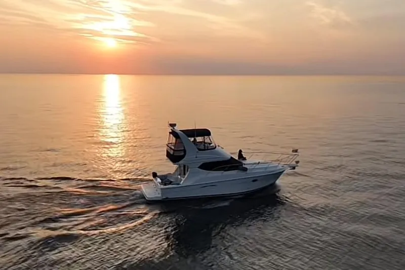  Yacht Photos Pics 2005 Silverton 34 Convertible yacht cruising at sunset on calm waters.
