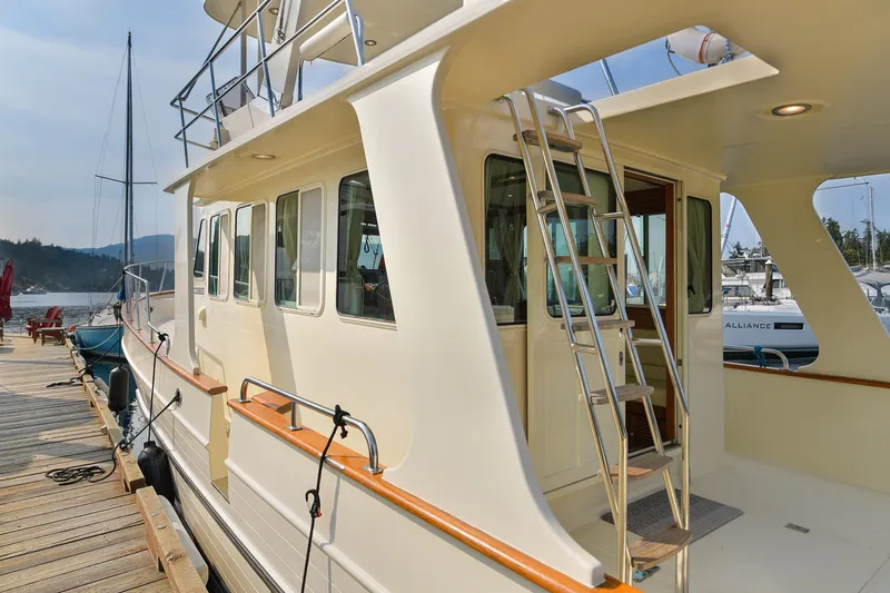 Island Harmony Yacht Photos Pics 2012 North Pacific 38 Sedan yacht docked at marina with ladder and windows.