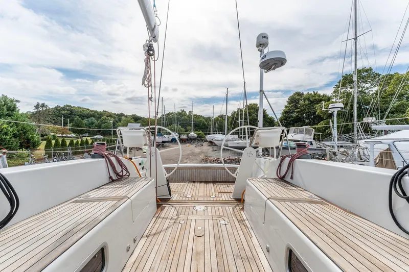 Rusalka Yacht Photos Pics Italia Yachts 13.98 (2015) sailboat with wooden deck, docked in a marina.