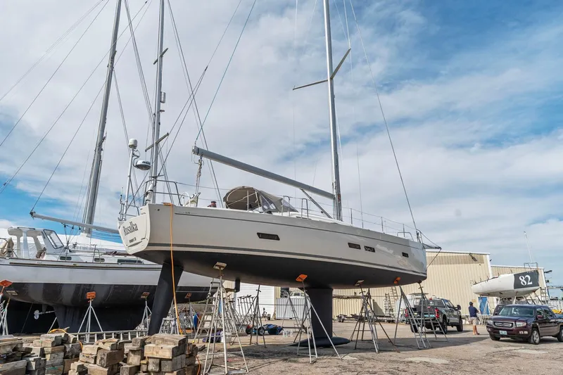 Rusalka Yacht Photos Pics 2015 Italia Yachts 13.98 sailboat on dry dock, surrounded by other boats and vehicles.