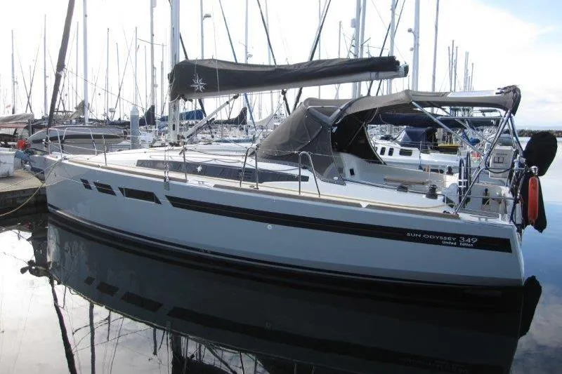 Naia Grey Yacht Photos Pics 2022 Jeanneau Sun Odyssey 349 sailboat docked in marina, sleek design, calm water reflection.