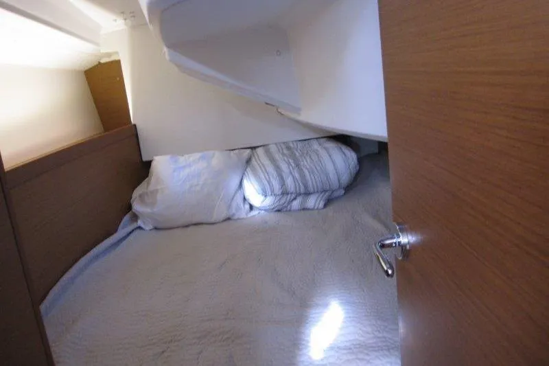 Naia Grey Yacht Photos Pics Cozy cabin interior of 2022 Jeanneau Sun Odyssey 349 sailboat with bed and pillows.