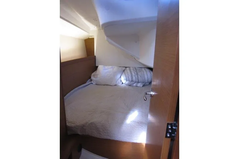 Naia Grey Yacht Photos Pics Cozy cabin interior of 2022 Jeanneau Sun Odyssey 349 sailboat with bed and pillows.