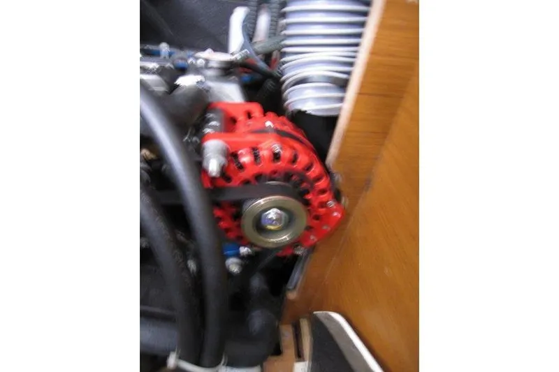 Naia Grey Yacht Photos Pics Engine component of 2022 Jeanneau Sun Odyssey 349 sailboat, featuring a red alternator.