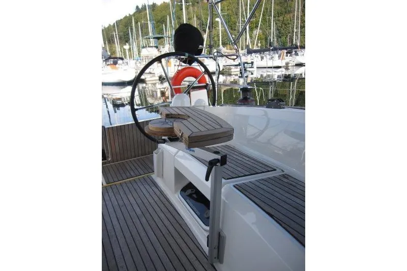 Naia Grey Yacht Photos Pics Cockpit of 2022 Jeanneau Sun Odyssey 349 sailboat with wooden seating and steering wheel.