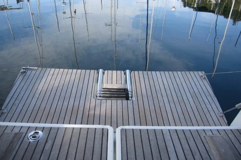 Naia Grey Yacht Photos Pics Jeanneau Sun Odyssey 349, 2022 model, swim platform with ladder, calm water reflection.
