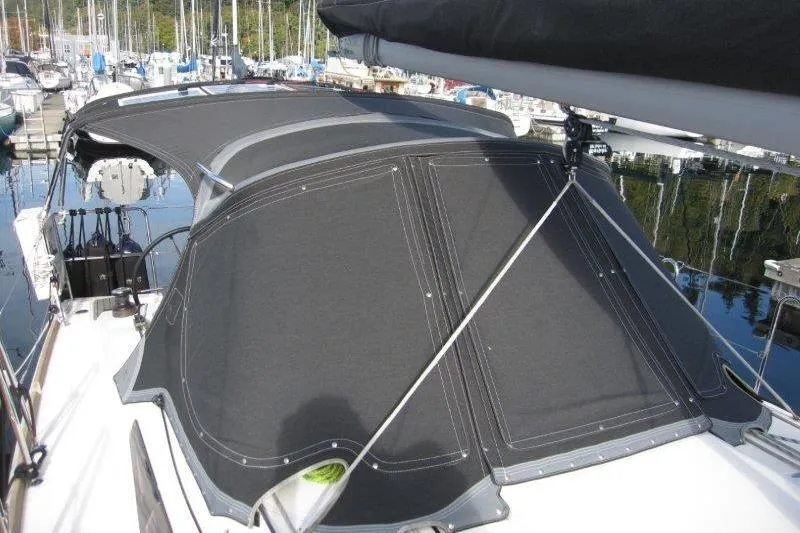 Naia Grey Yacht Photos Pics 2022 Jeanneau Sun Odyssey 349 sailboat with black canvas cover in marina.