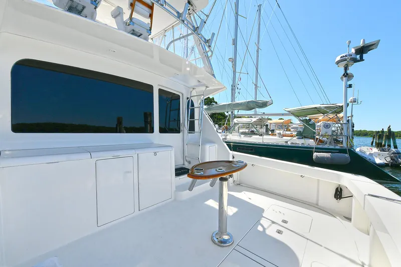 Salty Dog Yacht Photos Pics 2002 Viking 48 Convertible yacht deck with seating and table, docked at marina.