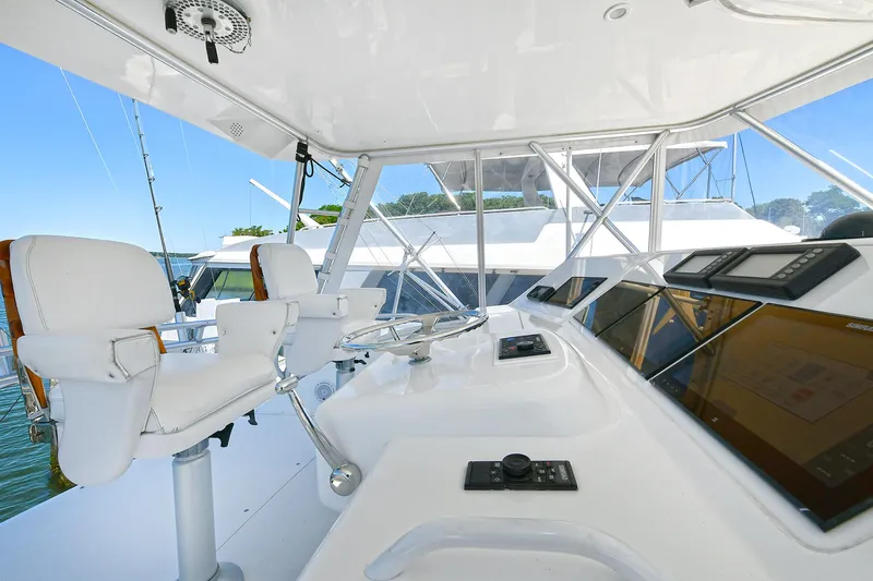Salty Dog Yacht Photos Pics 2002 Viking 48 Convertible yacht helm with white seating and modern controls.