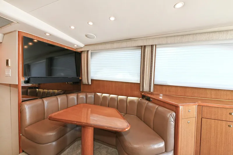 Salty Dog Yacht Photos Pics Luxurious interior of 2002 Viking 48 Convertible yacht with leather seating and wooden table.