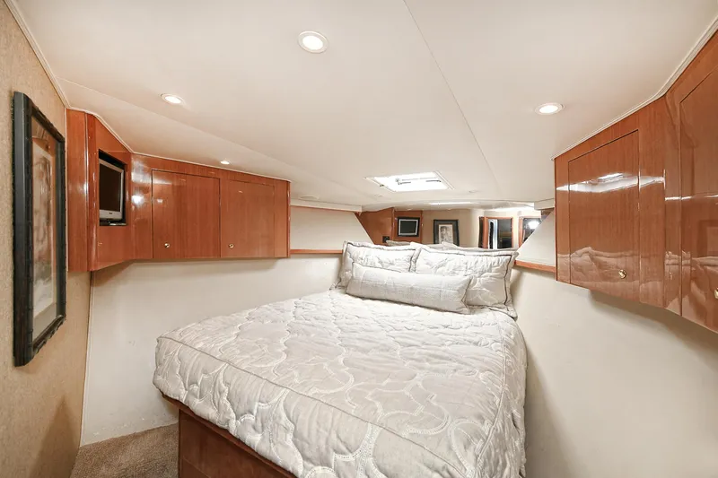 Salty Dog Yacht Photos Pics Luxurious bedroom interior of 2002 Viking 48 Convertible yacht with wood cabinets and cozy bedding.