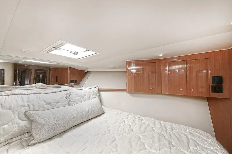Salty Dog Yacht Photos Pics Luxurious bedroom interior of 2002 Viking 48 Convertible yacht with wood cabinets and skylight.