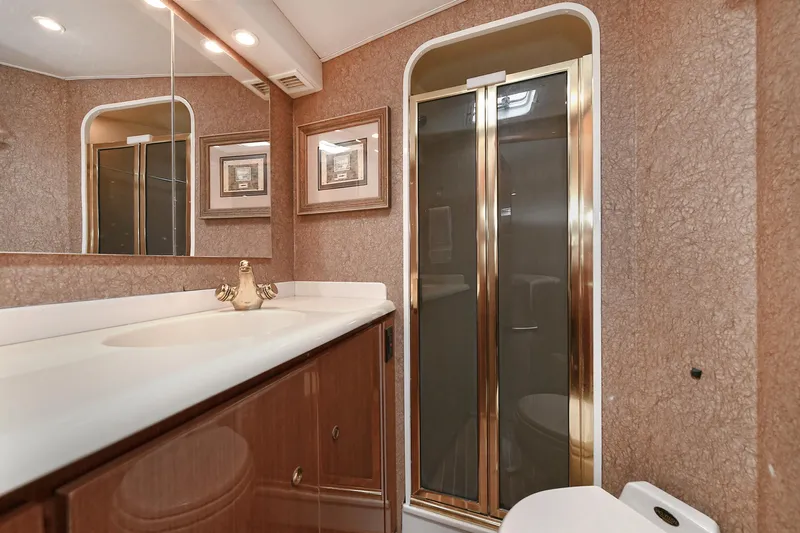 Salty Dog Yacht Photos Pics Luxurious bathroom in 2002 Viking 48 Convertible yacht with elegant fixtures and shower.