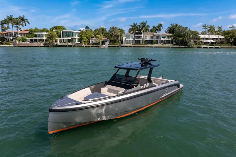  Yacht Photos Pics 2022 Vanquish VQ40 boat on water, luxury waterfront homes in background.
