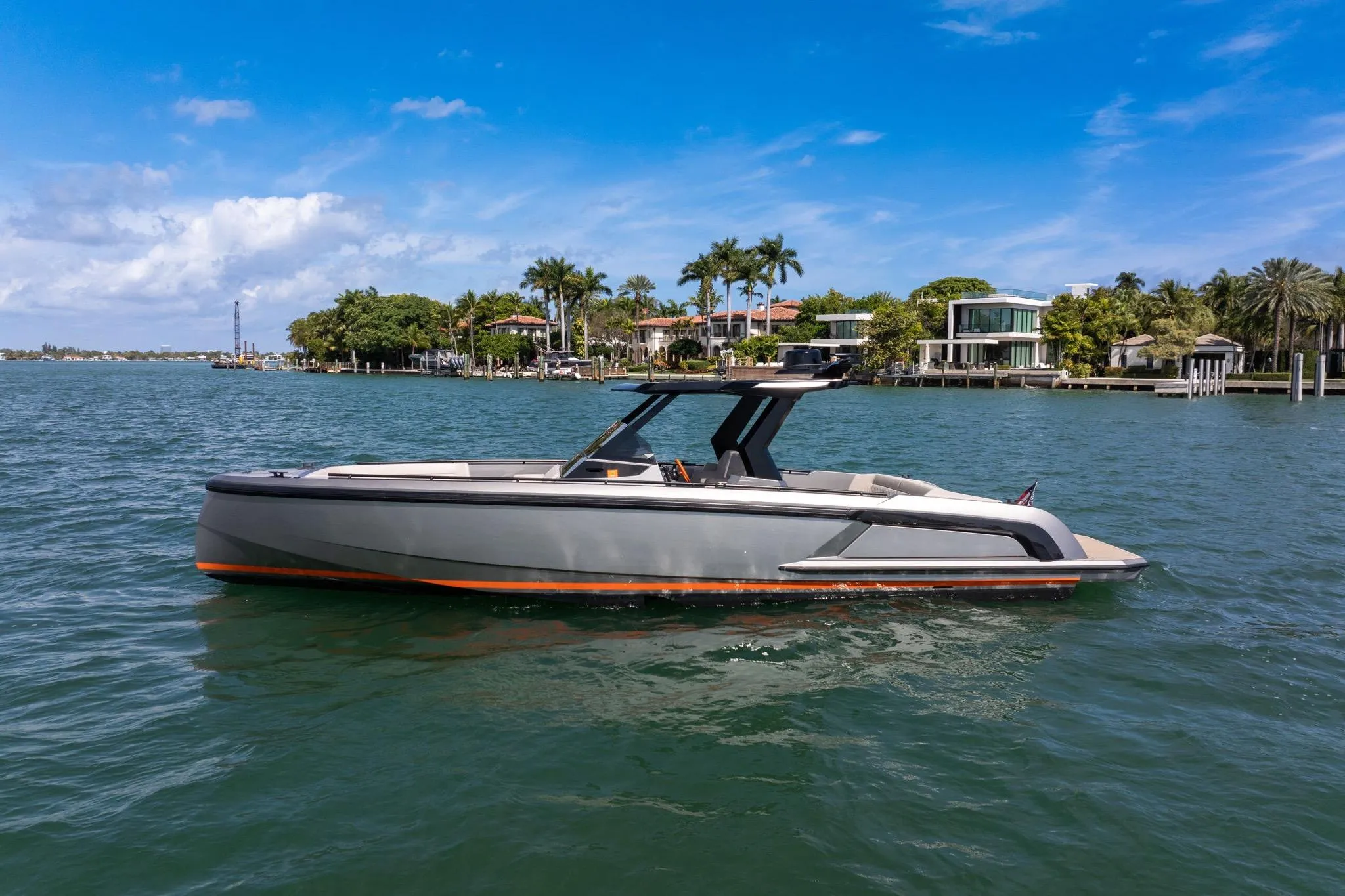 2022 Vanquish VQ40 luxury yacht cruising on a sunny day near waterfront homes.