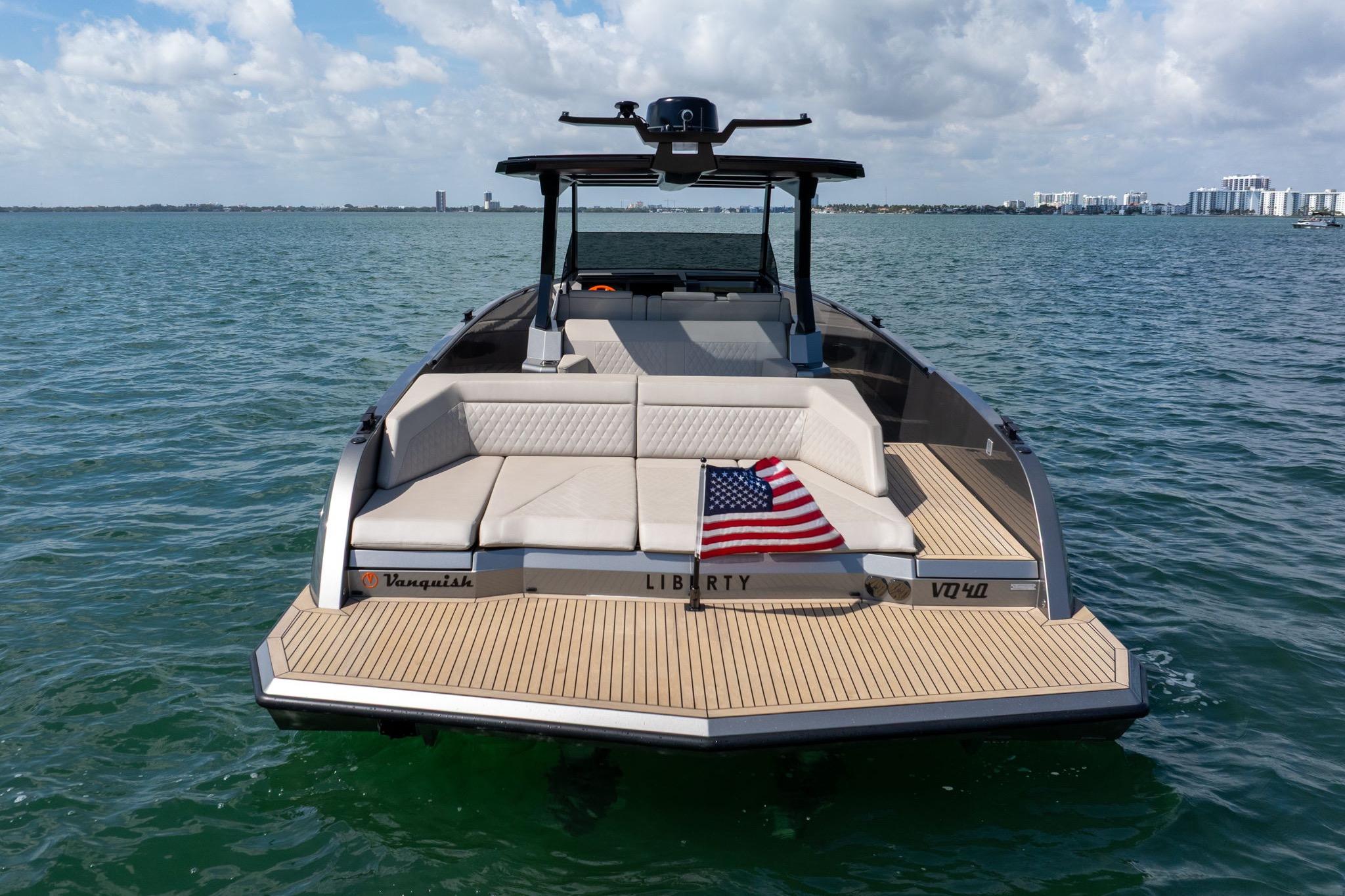2022 Vanquish VQ40 boat on water, rear view with American flag, clear sky.