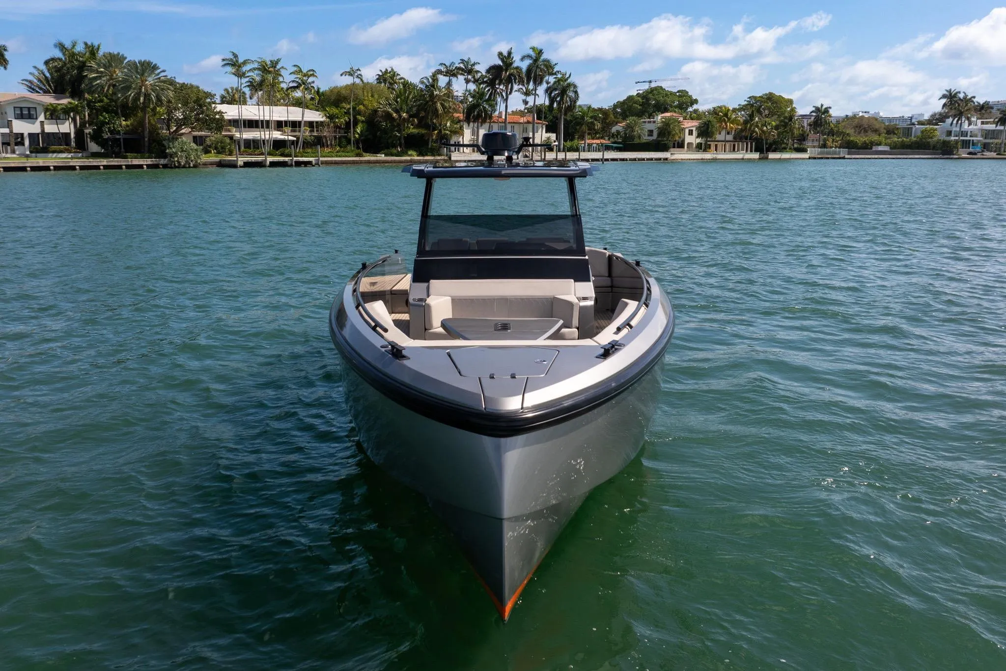 2022 Vanquish VQ40 luxury yacht on serene water with palm trees in the background.