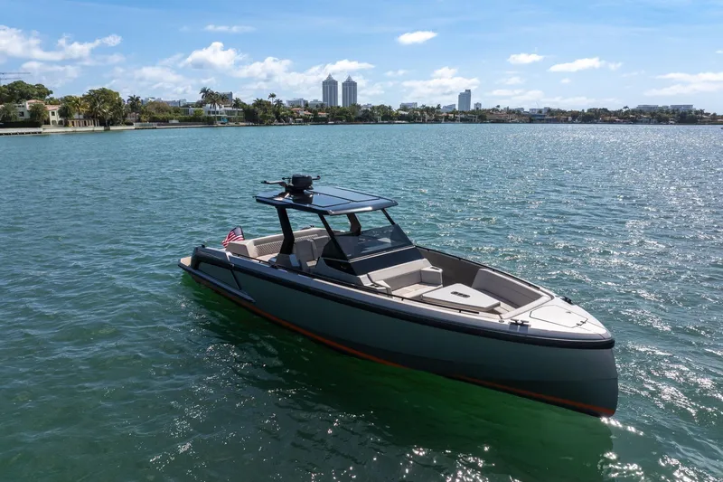  Yacht Photos Pics 2022 Vanquish VQ40 boat on calm water with city skyline in background.