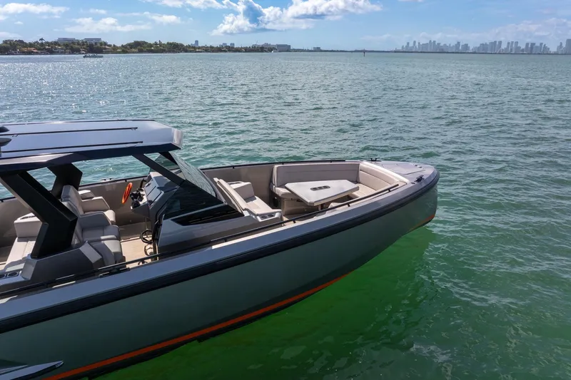  Yacht Photos Pics 2022 Vanquish VQ40 luxury yacht on calm waters with city skyline in background.