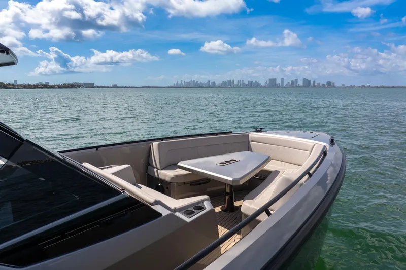  Yacht Photos Pics Luxurious 2022 Vanquish VQ40 yacht on serene waters with city skyline view.