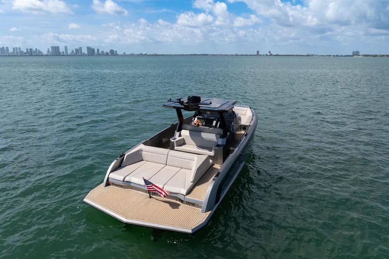  Yacht Photos Pics 2022 Vanquish VQ40 luxury yacht on open water with city skyline in background.