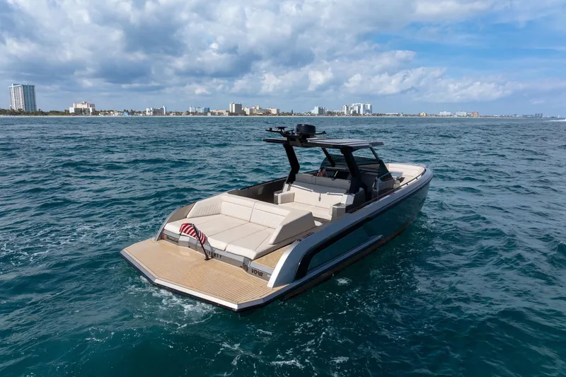  Yacht Photos Pics 2022 Vanquish VQ40 luxury yacht cruising on open water with city skyline backdrop.
