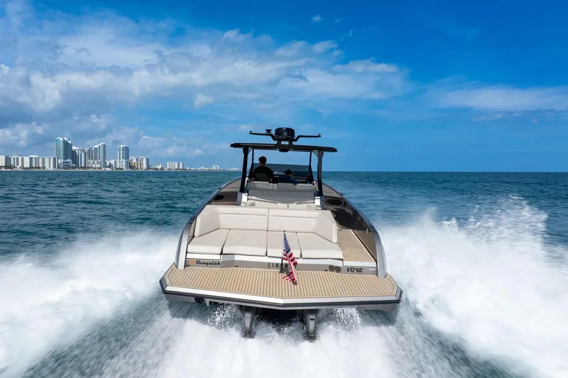  Yacht Photos Pics 2022 Vanquish VQ40 yacht cruising on ocean with city skyline in background.