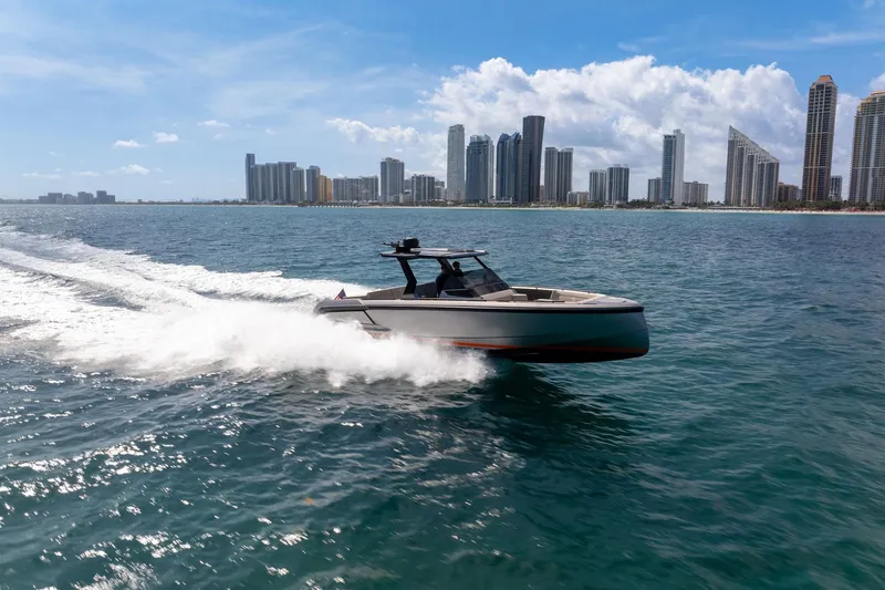  Yacht Photos Pics 2022 Vanquish VQ40 yacht cruising near city skyline on a sunny day.