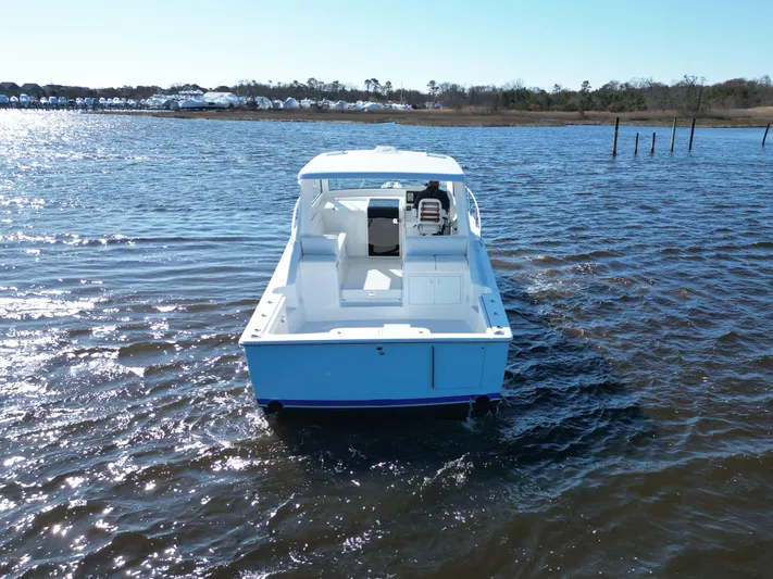  Yacht Photos Pics 2025 Henriques 35 Express Hardtop boat on calm water, rear view.